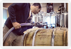 Worker filling a barrel at Elevation Brewing Company